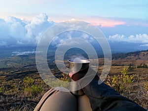 Holding Cup of Hot Tea During Sunrise Time on The Mountains