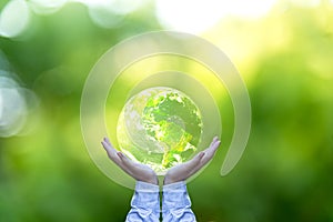 Holding a glowing earth globe in his hands.