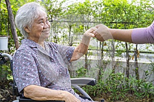 Holding hands Asian senior or elderly old lady woman patient with love, care, encourage and empathy at park