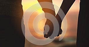 Holding hands, couple and sunset sky at beach with love on vacation, holiday or adventure. Man and woman silhouette