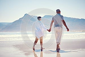 Holding hands, love and an old couple walking on the beach in summer with blue sky mockup from behind. Care, romance or