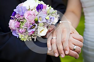 Holding hands newlywed with purple bouquet