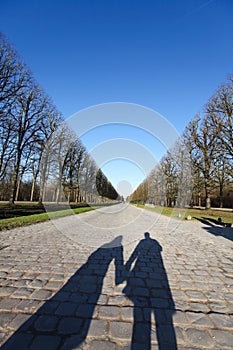 Holding hands shadow down a long path