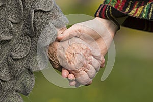 Holding hands together - old and young. Love.