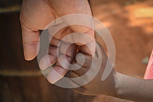 Holding hands of white man and black kid in Africa