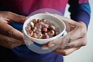 holding a hazelnuts bowl closeup