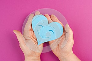 Holding a heart with a smiling face, colorful background with copy space, valintines day photo