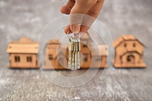 Holding house keys with blur houses model background