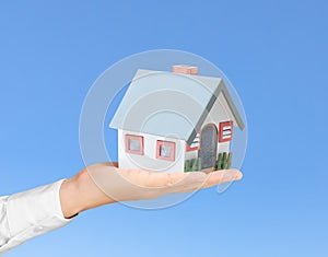 Holding house representing home ownership