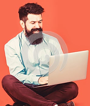 Holding laptop computer.Young businessman using his laptop, pc. Smiling handsome bearded man worker laptop. Happy young