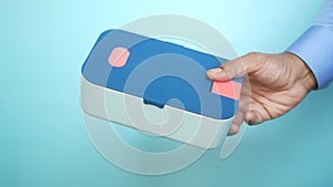holding a lunch box against blue background