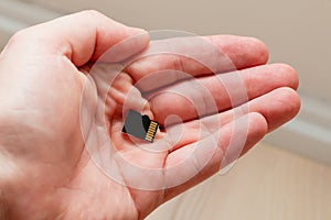Holding micro SDHC card in a hand - shallow focus