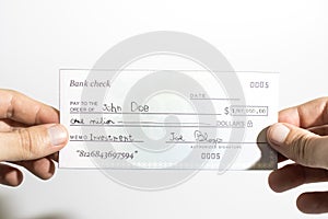 Holding a million dollar bank check isolated in a white background photo