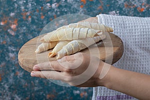 Holding mutaki cookies on a wooden board in the hand