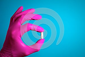 Holding pill capsule drugs in hand  pink latex glove