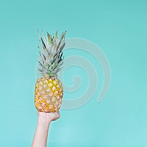 Holding a pineapple. Yellow nails. Girl hands.