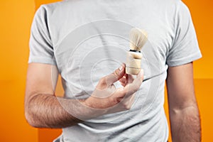 holding a shaving brush in his hand