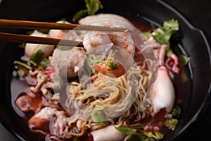 Holding shrimp Yentafo in black bowl