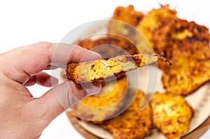 Holding slice of fried zucchini meatballs