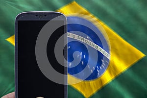 Holding smartphone with brazilian flag
