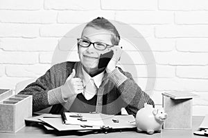 Holding and speaking on cell phone on white brick wall background, young cute businessboy