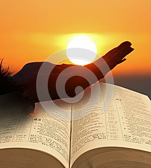 Holding sun in hand with open holy bible