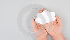 Holding a white cloud in the hand, empty copy space for text, gray background, communication and marketing concept, being connecte