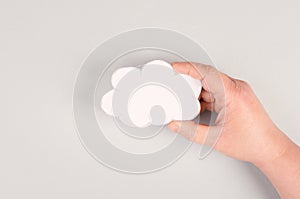 Holding a white cloud in the hand, empty copy space for text, gray background, communication and marketing concept, being connecte