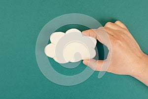 Holding a white cloud in the hand, empty copy space for text, gree background, communication and marketing concept, being connecte