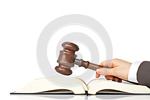 Holding a wooden gavel over the law book