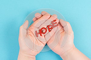 Holding the word hope in the palm of the hands, trust and believe concept, having faith in the future, hopeful positive mindset