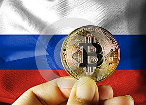 Holds a physical version of Bitcoin (the new virtual currency) and a Russian flag