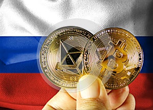 Holds a physical version of Bitcoin (the new virtual currency) and a Russian flag