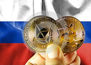 Holds a physical version of Bitcoin (the new virtual currency) and a Russian flag