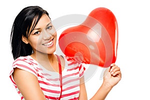 She holds your heart in the palm of her hand. a happy young african woman holding a heart shaped balloon against a