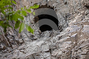 A hole in the bedrock wall resembles a cave. Ashabi-Kahf in Nakhchivan.