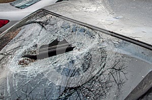 The hole in the broken windshield of the car