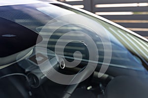 A hole in the center of the windshield made of stone from the wheels of the car in front.