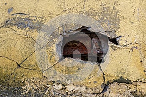 Hole with cracks in an old brick wall