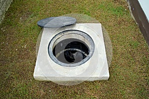 A hole of grease trap with the drain system around the house.