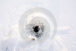 Hole in the ice-covered snow