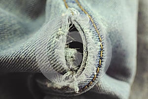 Hole in light gray jeans close-up. Homework for a seamstress