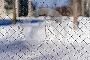 A hole in the mesh fence