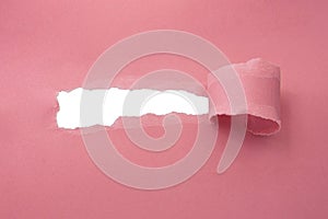Hole in paper pink color background damaged ripped