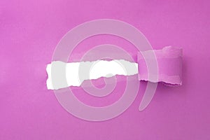 Hole in paper pink color background damaged ripped