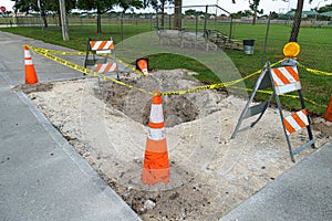 Hole in the road, construction site, blocked by orange cones, barricades and caution tape - Pembroke Pines, Florida, USA