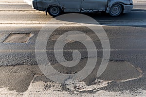 Hole, rut on asphalt road in the city. Road requiring repair, example of corruption in the repair of roads in Russia