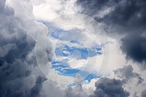 A hole in the stormy clouds revealing the blue sky