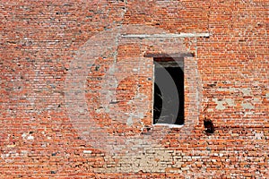 hole where a door should have been in the old brick wall of a crumbling industrial building