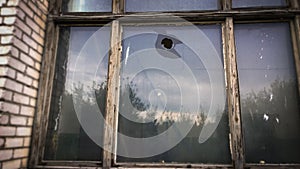 hole in the window pane of an old house. Glass broken by hooligans with a stone